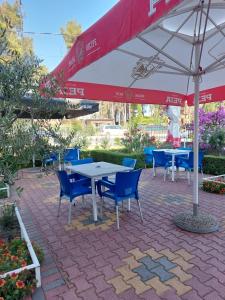 d'une terrasse avec des tables, des chaises et un parasol. dans l'établissement Vila Flamuri, à Golem