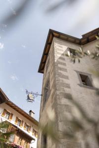 a tall stone building with a staircase on the side of it at Hotel Ansitz Steinbock in Villandro