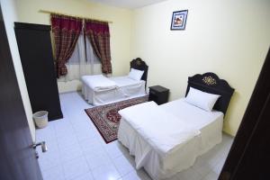 Cette chambre comprend 2 lits et une fenêtre. dans l'établissement العييري للوحدات السكنية القصيم 1, à Quaniya