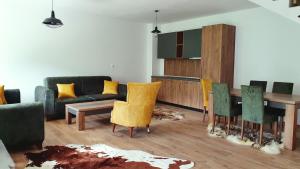 a living room with a couch and a table and chairs at Belle Resort in Deçan