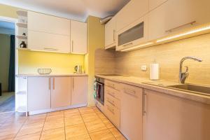 a kitchen with white cabinets and a sink at Schneider hause in Jūrmala