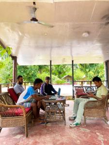 un grupo de personas sentadas alrededor de una mesa con ordenadores portátiles en Nature Safari Camp en Chitwan