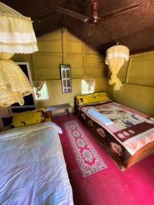1 dormitorio con 2 camas y alfombra rosa en Nature Safari Camp, en Chitwan