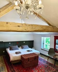 a bedroom with a large bed and a chandelier at Boutique B&B- The Riverside Retreat in Jarnac
