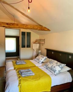 a bedroom with two beds with yellow sheets at La Rive Chambre d hôtes The Riverside Retreat in Jarnac