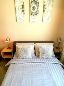 a bedroom with a bed with pillows and paintings on the wall at Melsky Apartment Dubai in Dubai