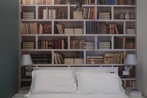 ein Schlafzimmer mit einem Bett und Bücherregalen mit Büchern in der Unterkunft OreaSpiti - Not Only a Suite in Magenta Quarter in Mailand