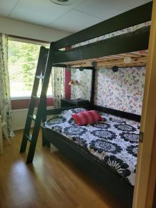 ein Schlafzimmer mit einem Etagenbett mit einer Leiter in der Unterkunft Niittyvilla Apartments in Jämsä
