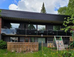 ein Haus mit einer umlaufenden Veranda mit einer Terrasse in der Unterkunft Niittyvilla Apartments in Jämsä
