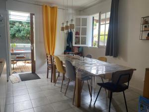 uma sala de jantar com mesa e cadeiras em Ti kaz bo - Chambre vanille chez l'habitant em Bras-Panon