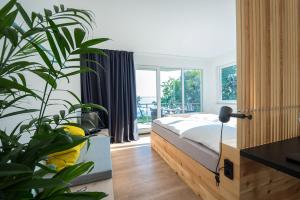 ein Schlafzimmer mit einem Bett und einer großen Pflanze in der Unterkunft Design-Suite am See in Ascheberg