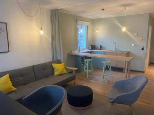 a living room with a couch and a kitchen at Design-Suite am See in Ascheberg