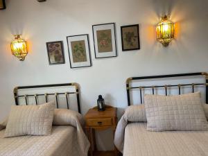 1 dormitorio con 2 camas y 2 luces en la pared en Vivienda Turística Rural Casa Irene, en Segura de la Sierra