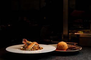 two plates of food sitting on a table at Tropicana Hotel , Suites & Villas Mykonos in Paradise Beach