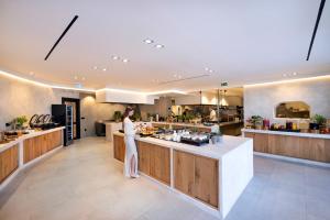 a woman standing at a counter in a kitchen at Tropicana Hotel , Suites & Villas Mykonos in Paradise Beach +37 photos