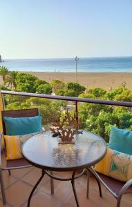 a table on a balcony with a view of the beach at Seaside in Gran Tarajal