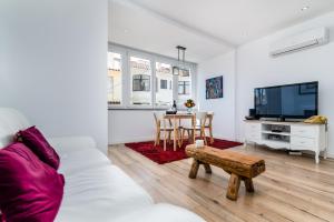 a living room with a couch and a tv and a table at T2 Tiles Apartment Estoril in Estoril