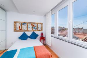a bedroom with a bed and a large window at T2 Tiles Apartment Estoril in Estoril