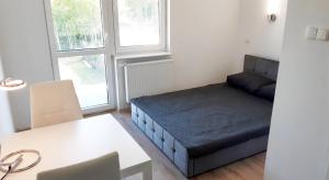 a small room with a bed and a table at Apartamenty Słoneczne Tarasy in Mrzeżyno