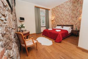 a bedroom with a bed with a red blanket at Mooste Viinavabriku Hotell & Restoran in Mooste +139 photos