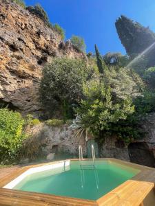 una piscina frente a una montaña rocosa en Le jardin de Camille, en Cotignac