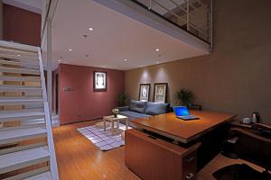 a living room with a laptop on a desk at Zou Qu Ye Travel Hotel in Chongqing