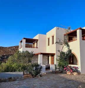 a large white building with flowers in front of it at Litois Houses Patmos in Sapsila