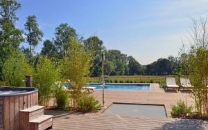 a backyard with a swimming pool and a wooden deck at Château Saint Gilles in Bayeux