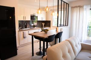 a kitchen and living room with a table and a couch at L'ÉLÉGANCE DU VIGNY in Divonne-les-Bains