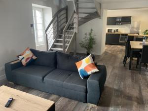 a living room with a blue couch and a staircase at Les Appartements - Les Anges Béarnais I et Les Anges Béarnais II in Sauveterre +27 photos