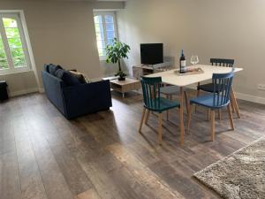 a living room with a table and chairs and a couch at Les Appartements - Les Anges Béarnais I et Les Anges Béarnais II in Sauveterre