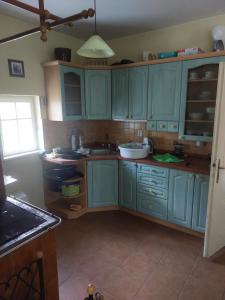 uma cozinha com armários azuis e uma janela em Chalupa na samotě u lesa em Provodov