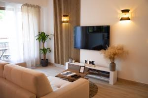 uma sala de estar com um sofá e uma televisão de ecrã plano em L'ÉLÉGANCE DU VIGNY em Divonne-les-Bains
