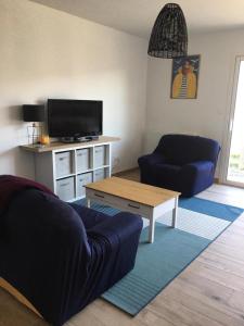 uma sala de estar com um sofá e uma mesa de centro em Maison cosy à 400 m de la mer! em Saint-Vincent-sur-Jard