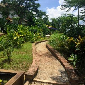 ceglana ścieżka w ogrodzie z roślinami w obiekcie Zen Résidence Laos #5 to #8 w mieście Luang Prabang
