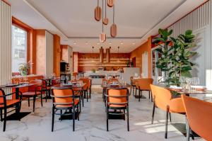 um restaurante com cadeiras e mesas cor de laranja e um bar em Hotel Central Park em Poděbrady