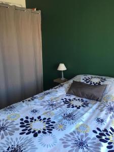 um quarto com uma cama com um cobertor azul e branco em Maison cosy à 400 m de la mer! em Saint-Vincent-sur-Jard