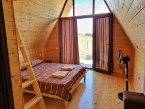 ein Schlafzimmer mit einem Bett in einem Holzhaus in der Unterkunft Cottage in Udabno in Udabno