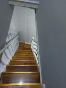 a staircase with wooden floors and a white wall at Hanwell House in Liverpool