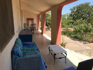 a porch with two blue chairs and a table at Cosy apartment in a relaxing area close to Lecce in Frigole