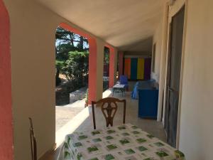 a room with a table and a chair on a porch at Cosy apartment in a relaxing area close to Lecce in Frigole