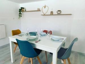 a white dining room table with blue chairs and a white table at Appartamento con giardino, La Casa di G&G in Marina di Carrara