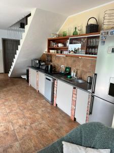 a kitchen with a sink and a refrigerator at Dom w Trawach in Smołdziński Las