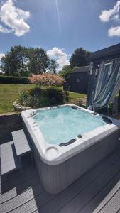 a large bath tub sitting on a deck with at Bluebell House 5 Star Holiday Let in Somerton