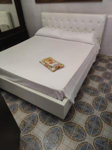 een bed op een vloer met een bord erop bij Al Piccolo Alloggio in San Carlo
