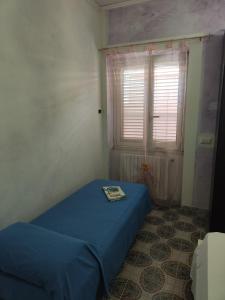Un dormitorio con una cama azul y una ventana en Al Piccolo Alloggio en San Carlo