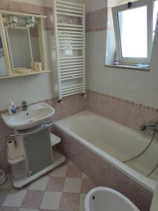 een badkamer met een wastafel, een bad en een toilet bij Al Piccolo Alloggio in San Carlo