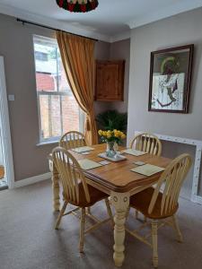 uma mesa de jantar com cadeiras e um vaso de flores em Character Beverley Town House em Beverley