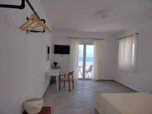 a white room with a bed and a table and a desk at Bay-dream 1 in Adamas
