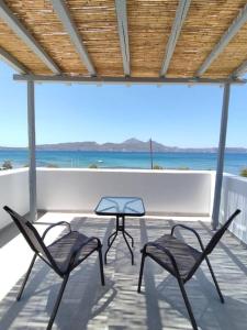two chairs and a table on a balcony with the ocean at Bay-dream 1 in Adamas